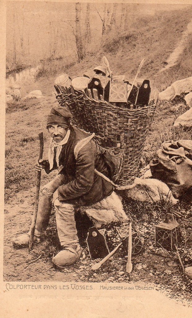 Hausierer mit seiner Kiepe voller heterogener Waren in den Vogesen, Postkarte, 1925.